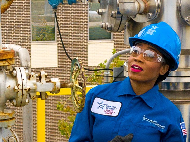 Person wearing a hard hat on a platform.