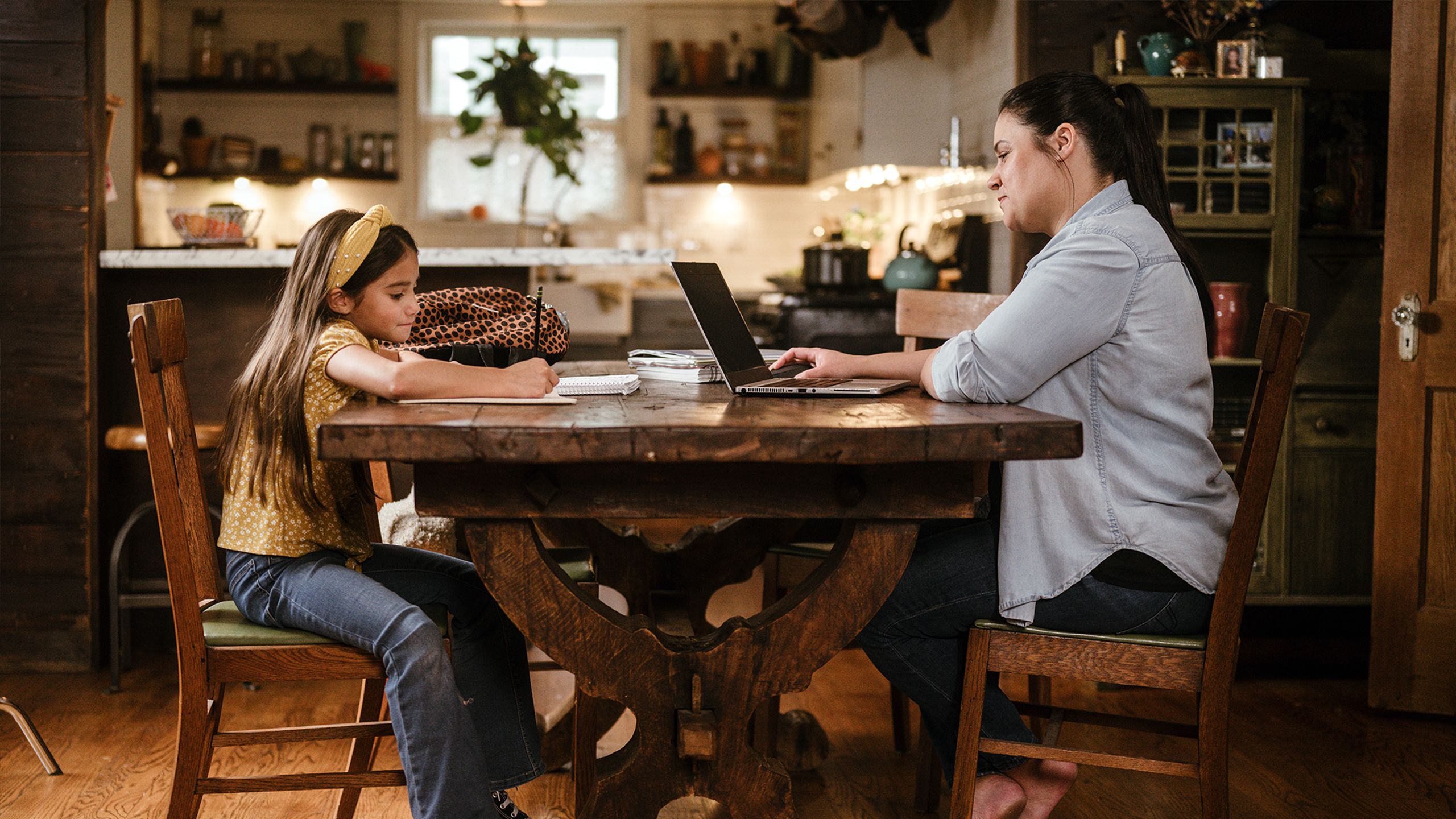 Mother and daughter at dinner table.